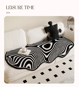 Modern black and white wavy pattern irregular sofa mat on white couch with decor