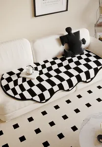 Modern irregular checkerboard sofa cushion with wavy edges on white minimalist couch