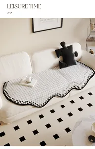 Detailed view of cream irregular sofa cover with houndstooth trim on a white sofa