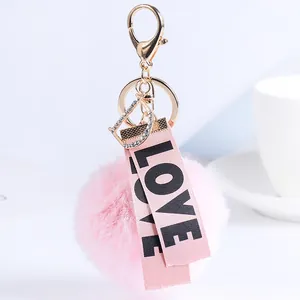 Detailaufnahme eines weichen rosa Kunstfell-Schlüsselanhängers mit LOVE-Bändern und D-Anhänger