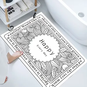 Detailed view of white diatom mud bath mat with black floral pattern and English text