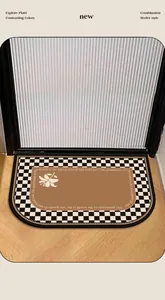 Detail of a mid-century style absorbent floor mat with checkerboard border and floral motif