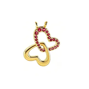 Detailed view of gold-plated butterfly pendant with interlocking hearts and red stones