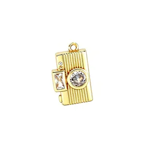 Dettaglio di un ciondolo fotocamera vintage dorato con zirconi brillanti