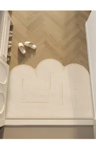 Paillasson moderne en PVC crème avec motifs géométriques sur sol en bois de chevrons