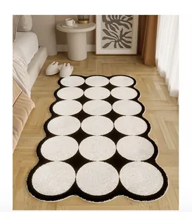 Dettaglio del tappeto da comodino in peluche irregolare con pois bianchi e neri