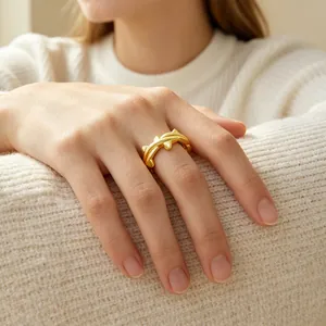Gold plated thorn open ring worn on finger against a cozy white knitted sweater
