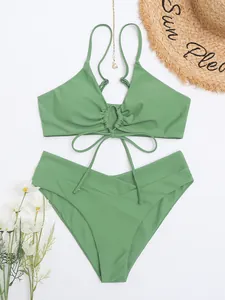 Bikini a due pezzi verde salvia con top con lacci e slip a vita alta incrociati.