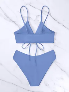 Dettaglio posteriore di un set bikini blu con top allacciato e slip a vita alta.