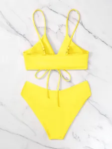 Vista posteriore dettagliata di un bikini giallo vivace con lacci su marmo bianco