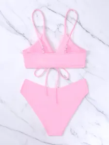Vista dettagliata del bikini rosa a due pezzi con spalline regolabili su fondo marmo