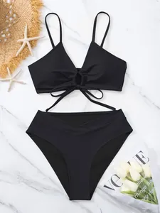Dettaglio del set bikini nero a due pezzi con anello anteriore e slip a vita alta.