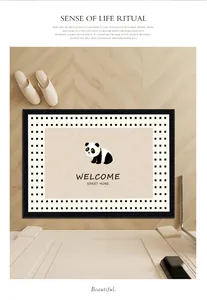 Detailed view of a cute panda welcome mat with Sweet Home text on light wood floor.