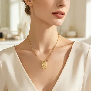 Collier vintage plaqué or avec pendentif croix et oiseau en zircone sur un modèle