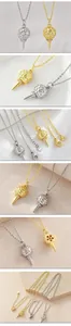 Gros plan de pendentifs tee de golf en or et argent avec détails en zircone.