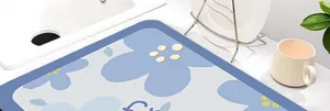 Detail van een blauwe bloemige absorberende keukenmat op een wit aanrecht