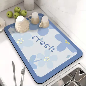 Florale absorberende afdruipmat voor de keuken voor borden en kopjes op het aanrechtblad.