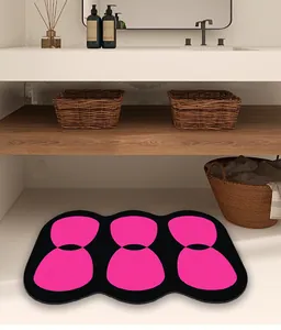 Alfombra de baño absorbente moderna en rosa y negro con bordes ondulados en ambiente real