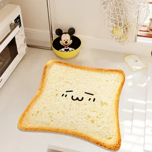 Dettaglio di un simpatico tappetino da cucina a forma di pane con un viso felice