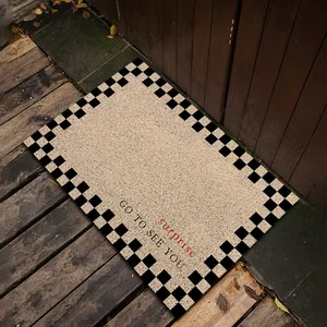 Macro detail of the anti-slip PVC silk loop doormat featuring a checkerboard border and text