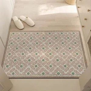 Detailed view of a pinkish geometric silk loop entrance door mat in a home hallway.