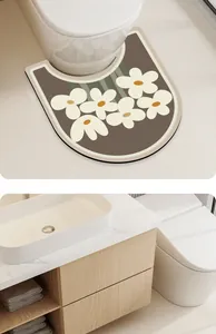 Detailed view of U-shaped diatom mud toilet mat with white floral pattern on brown base.