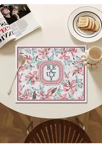 Close-up of floral leather placemat with BEAUTY text on a modern white dining table.