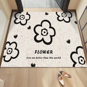 Detail view of cream silk ring floor mat with black floral pattern and English text
