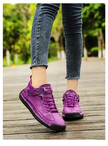 Purple hand-stitched leather loafers for women with soft rubber sole on wooden deck.