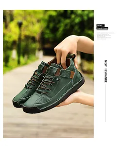 Close-up of hand-stitched green leather casual shoes held by hands in a nature park setting