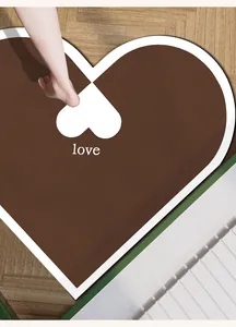 Close-up van een bruine hartvormige absorberende badmat met witte 'love' tekst op de vloer