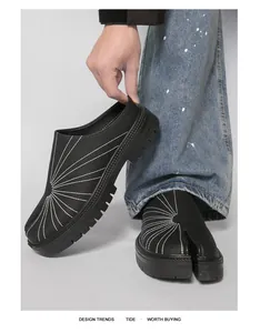 Detailed close-up of men's black leather tabi mules featuring white radial stitching
