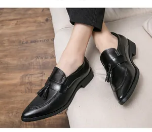 Vista detallada de elegantes mocasines negros para hombre con borlas y punta puntiaguda