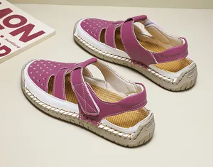 Detailed view of women's breathable magenta and white hollow-out summer beach sandals