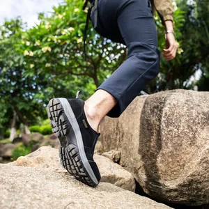 Detailed macro shot of durable men's outdoor hiking shoes stepping on a rock surface.