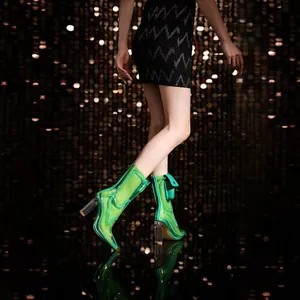 Side view detail of neon green transparent PVC chunky heel boots with decorative pocket