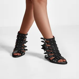 Vue détaillée de bottes sandales noires à clous avec découpes et boucles ornées