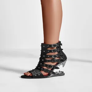 Détail de bottines sandales noires punk avec clous et talon en forme de crocs