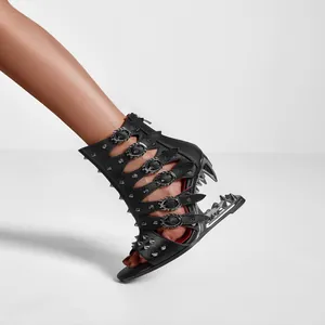 Gros plan de sandales bottines noires à bout ouvert avec rivets et talon griffu.