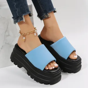 Close-up of blue puffy strap platform sandals with chunky black soles on model