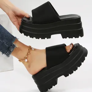 Detail view of the chunky platform sole and textured finish on black slide sandals