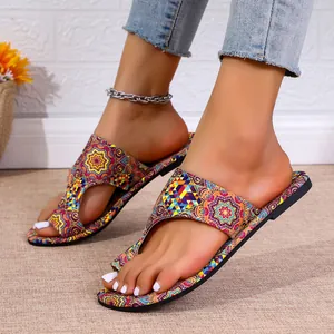 Detailopname van etnische platte sandalen met kleurrijke geometrische bloemenpatronen