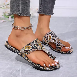Detailweergave van bohemian platte damessandalen met paisley-print en stijlvol teenlus-ontwerp