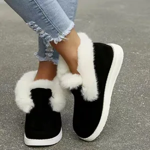 Detailed view of women's black suede snow boots with thick white faux fur lining for winter