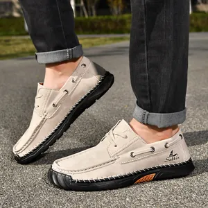 Side view of beige men's casual shoes featuring detailed hand-stitching and brand logo