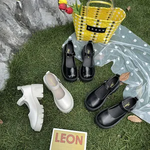 Close-up view of stylish black and white platform Mary Jane shoes displayed on green grass