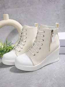 Side view of fashionable cream wedge high-top canvas shoes with white toe cap and side zipper