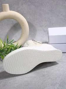 Detailed view of the wave-textured non-slip white sole of a women's wedge canvas shoe.