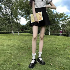 Close-up of black platform Mary Jane shoes styled with white lace socks and a skirt