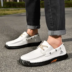 Detail view of white hand-stitched PU leather loafers for men on outdoor pavement